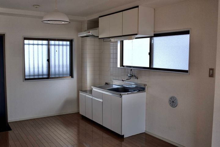 真っ白な殺風景な部屋の内装。窓があるキッチン。