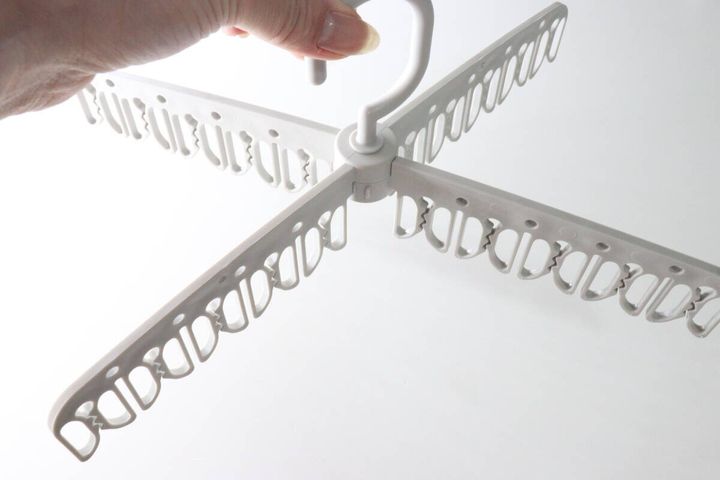 女性の手がダイソー洗濯ハンガーを十字に広げている様子