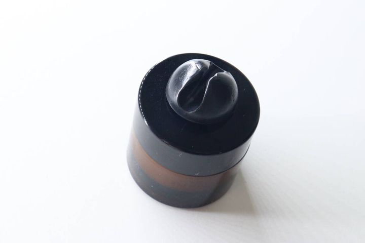 黒いコスメジャーの蓋に貼り付けられたスパチュラホールド