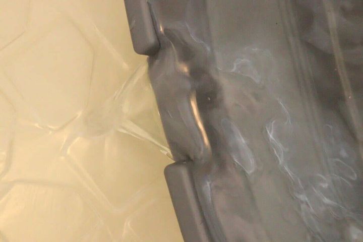 折り畳みたらいのフチにある注ぎ口から水が勢いよく流れ出ている様子