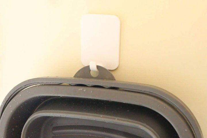 折り畳まれたたらいがフック穴を使って壁に引っ掛けられている様子