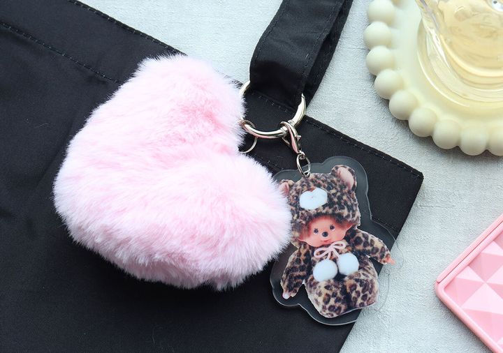 黒いバッグに付けたピンクのファーとモンチッチチャーム