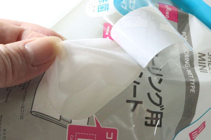 指でダイソーお掃除シートのフタを開け、中からシートを取り出している手元