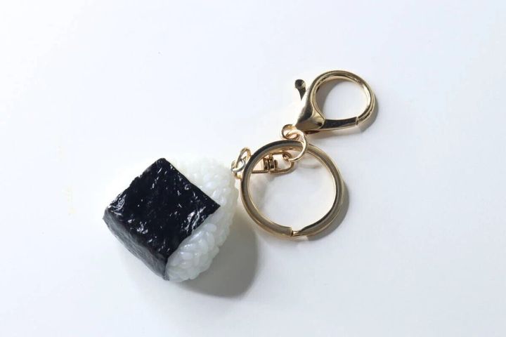 白い背景に置かれた、海苔付きおにぎりの食品サンプルキーホルダー