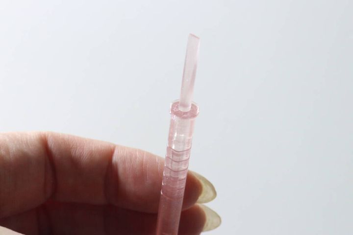 女性の手が六角形のネイル用スティックを持っている様子