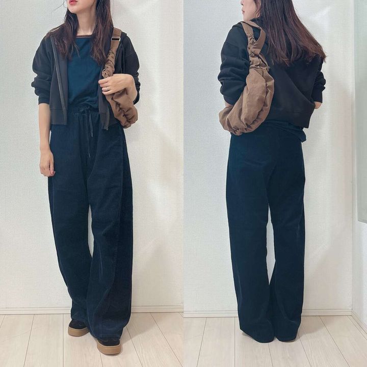 黒いパーカーと黒いバレルパンツを着用した女性のカジュアルコーデ