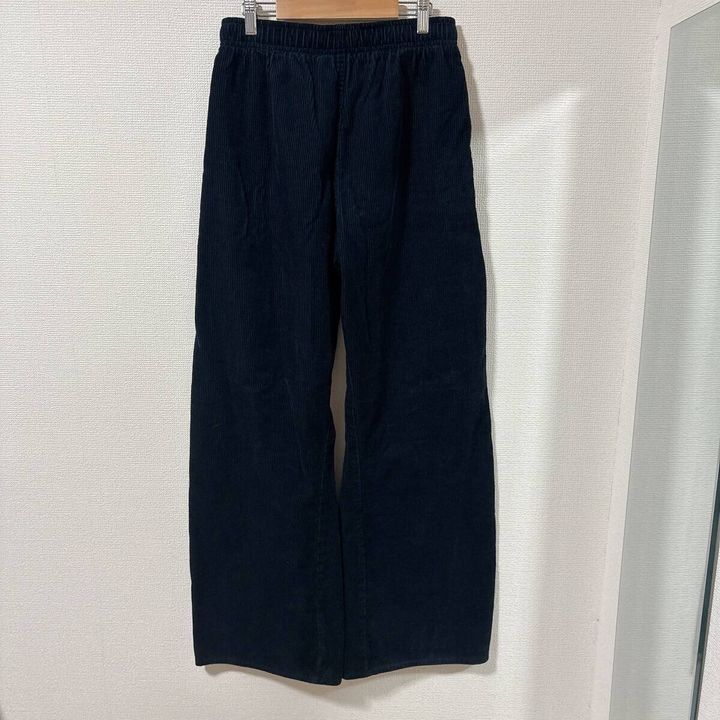 黒いコーデュロイバレルパンツがハンガーに吊るされている背面