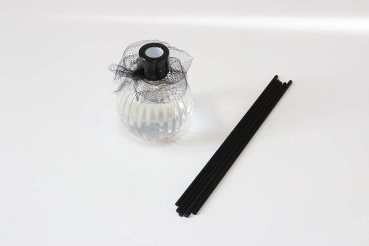 レース装飾ディフューザーの空ボトルと黒いスティック