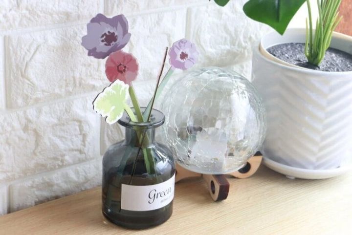 花のペーパー飾りを挿したディフューザーとガラスのオブジェ