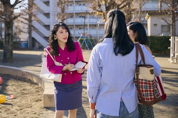 ショッキングピンクのダブルブレストのスーツに真紅のリップが目を引く上原恵 [c]2026「ファーストボイス」製作委員会
