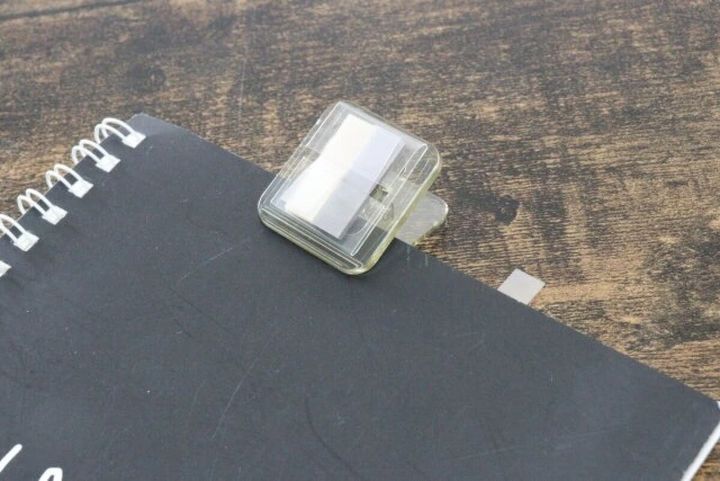 透明なクリップ付箋が黒いノートに挟まっている