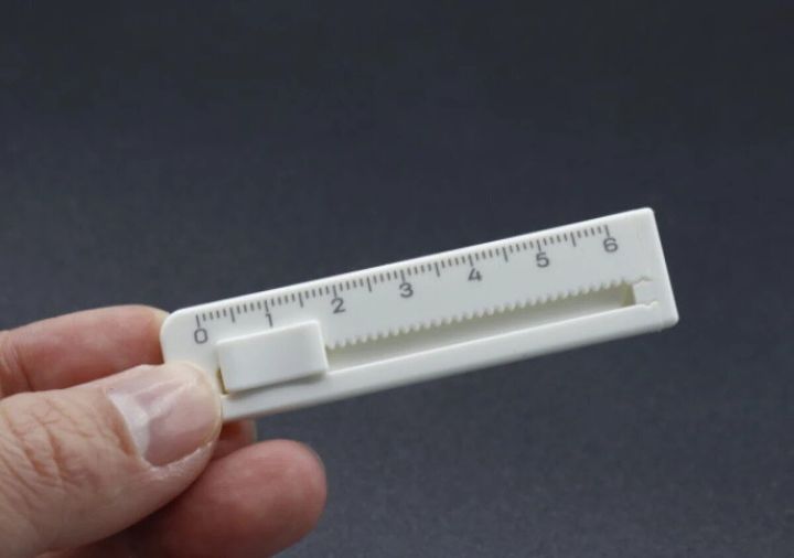 白いミニカッターを指でつまんで持っている様子