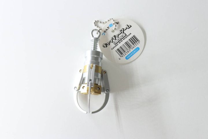 白い背景に置かれたキャッチャーアームキーホルダーと商品タグ