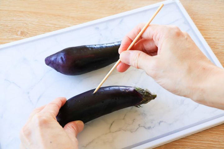竹串でなすに穴をあける様子