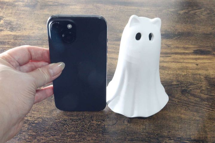 女性の手が持つスマホと白いゴーストオブジェを並べてサイズ比較