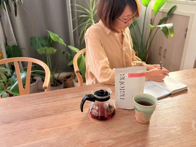 テーブルでノートを書く女性