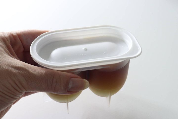 落とし蓋とフタをした味玉名人の容器を女性が手に持つ