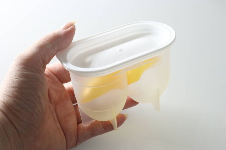 女性の手のひらに乗せたセリアの味玉名人容器とフタ