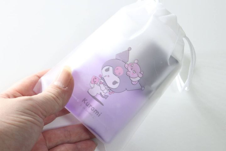 女性の手がクロミ巾着ポーチにボトルを入れている