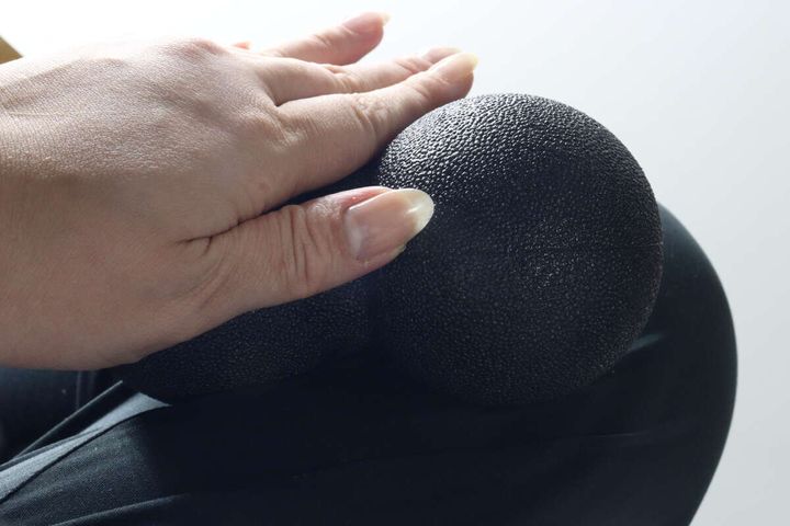 太ももにリフレッシュボールを当てて転がす手元