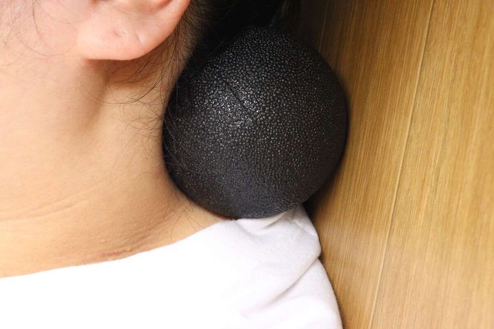 寝転がって後頭部にリフレッシュボールを当てている様子