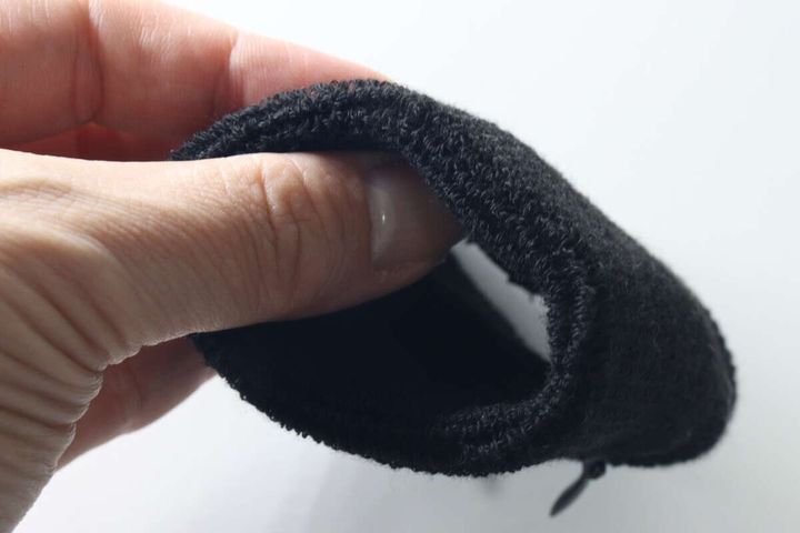 指で黒いリストバンドを握り厚みとふかふかした素材感を見せる