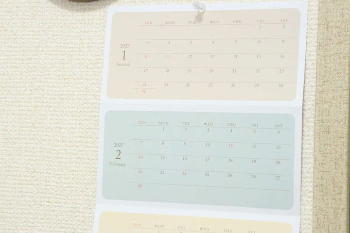 壁にピンで留められたダイソーの蛇腹カレンダー