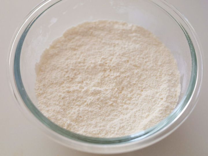 透明なボウルに薄力粉とベーキングパウダーが混ざった白い粉
