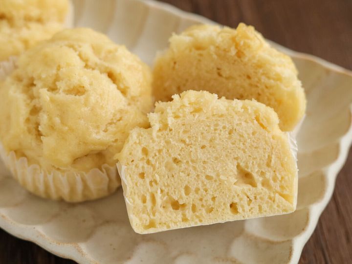 白い長方形の皿に盛り付けられた豆腐蒸しパンと、半分に割られて断面が見える蒸しパン