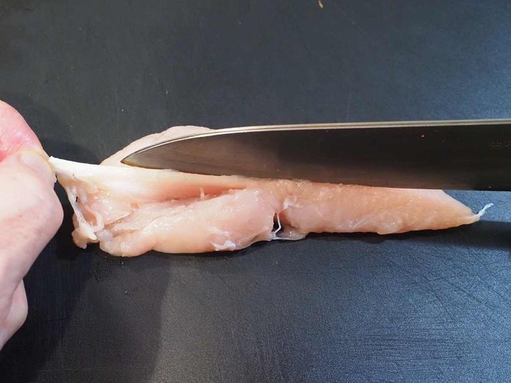 筋を取った鶏ささみに切り込みを入れる様子