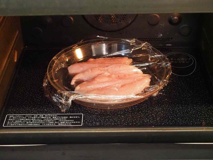 耐熱皿に並べた鶏ささみに日本酒をかける様子