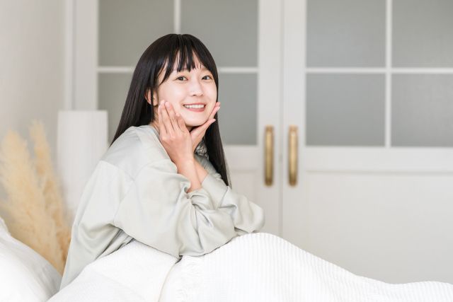 目覚めて伸びをする女性