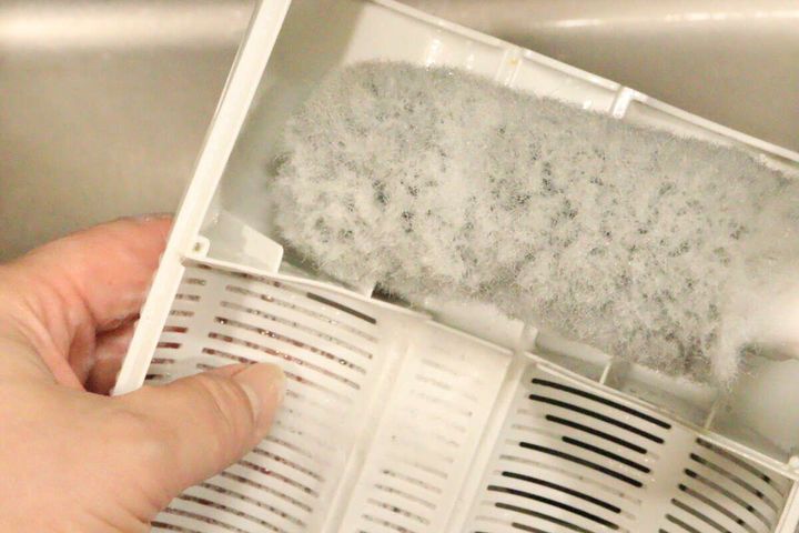 排水バスケットクリーナーでキッチンの排水バスケットの底面をこすり洗いしている様子