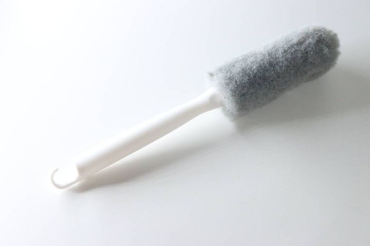 パッケージから出した排水バスケットクリーナーが白い背景に斜めに置かれている