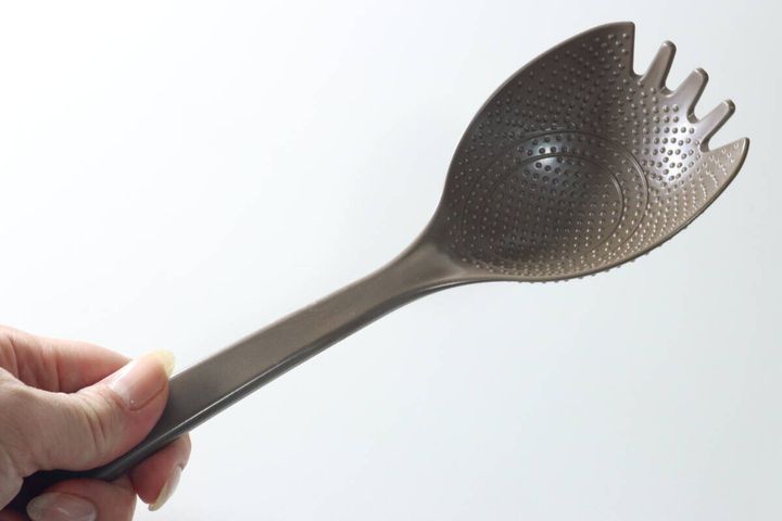 女性がダイソーの「チャーハンこれ1本」を手に持ち、全体を見せている