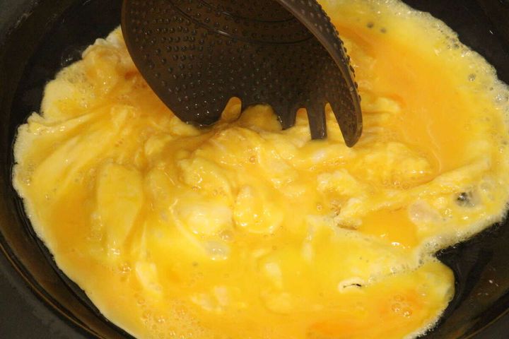 フライパンで溶き卵を炒める際に「チャーハンこれ1本」の先端で卵をほぐしている