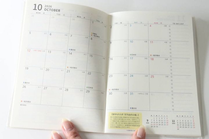 指で開かれた2026年10月の月間スケジュールページとTo Doリスト