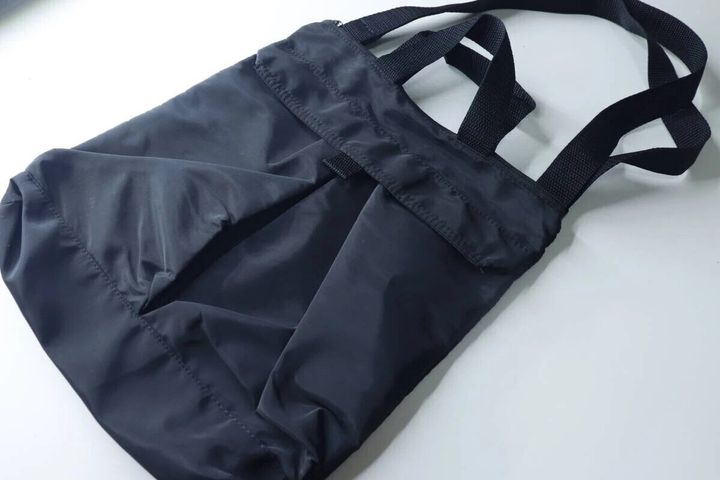 黒いナイロン製の2WAYショルダーバッグが白い背景に置かれている