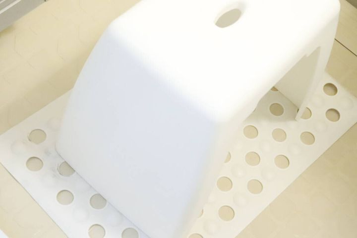 白い吸盤付浴槽マットの上に白いバスチェアが置かれている