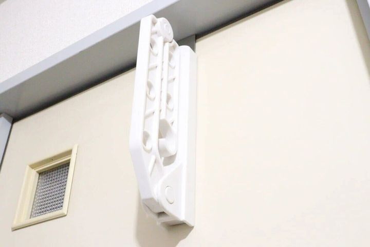 ドアに設置された折り畳み式物干しラックをたたんだ状態