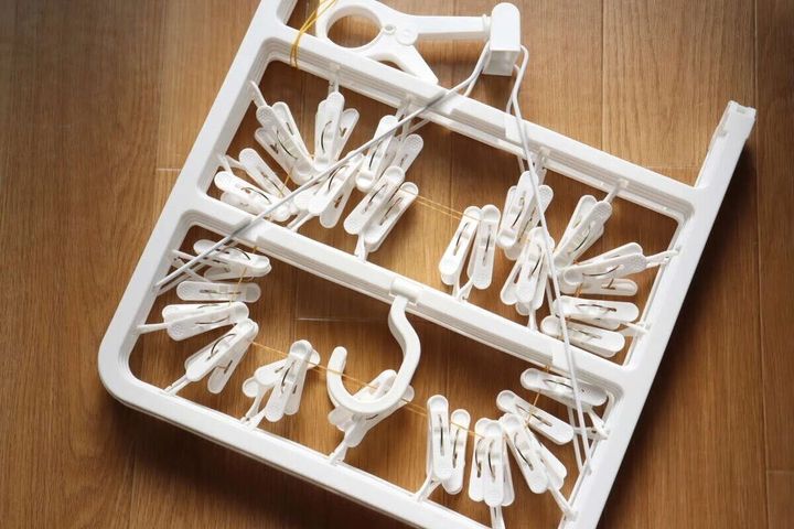 床に置かれた白いピンチハンガーの俯瞰写真