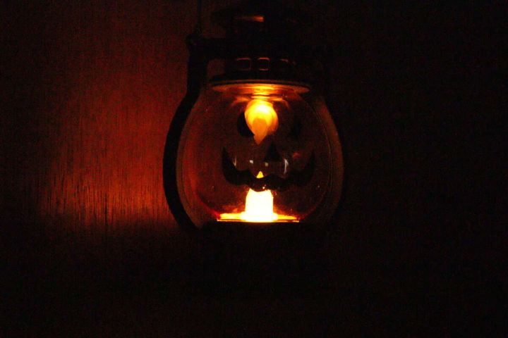 暗闇でLEDランタンが点灯し、かぼちゃの顔がぼんやりと光っている