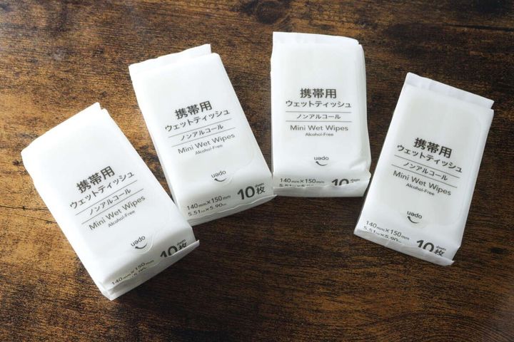 木目のテーブルに並べられた4つの個包装ウェットティッシュ