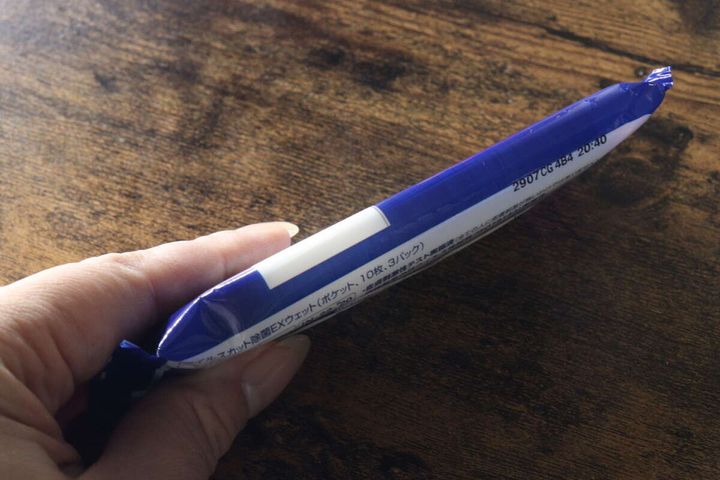女性の手のひらに乗せられたスリムな除菌ウェットティッシュ