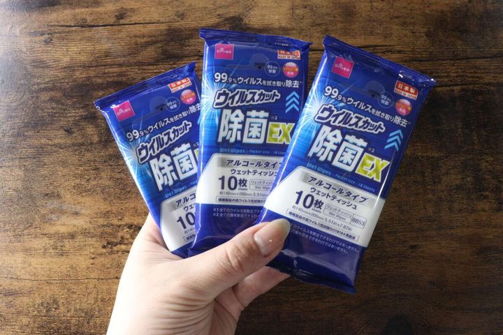 女性が3つの個包装除菌ウェットティッシュを手に持っている