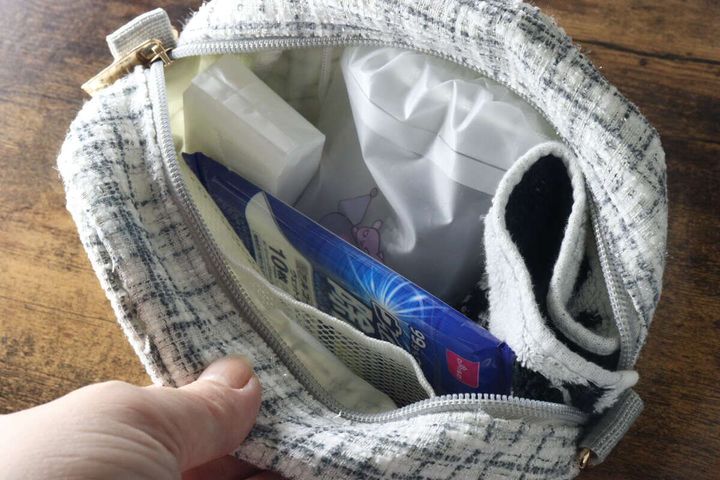 女性がミニバッグに除菌ウェットティッシュを入れている