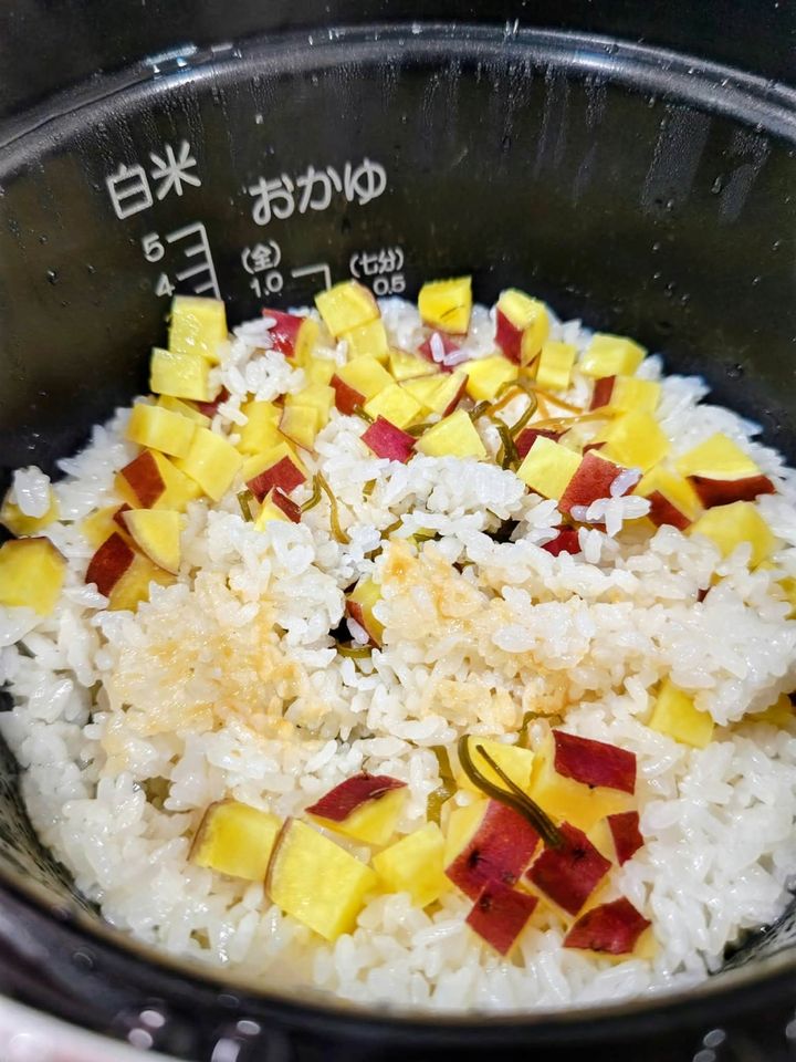 炊飯前のさつまいもと塩昆布をのせた米