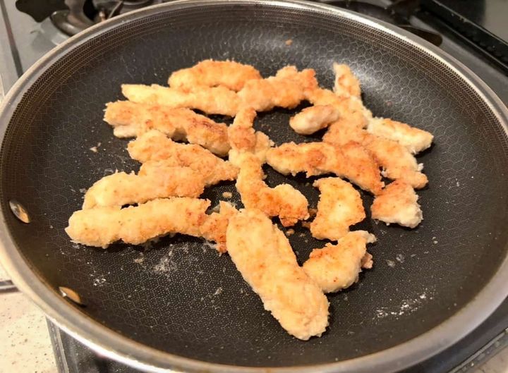 フライパンでクリスピーチキンを揚げ焼きにする様子