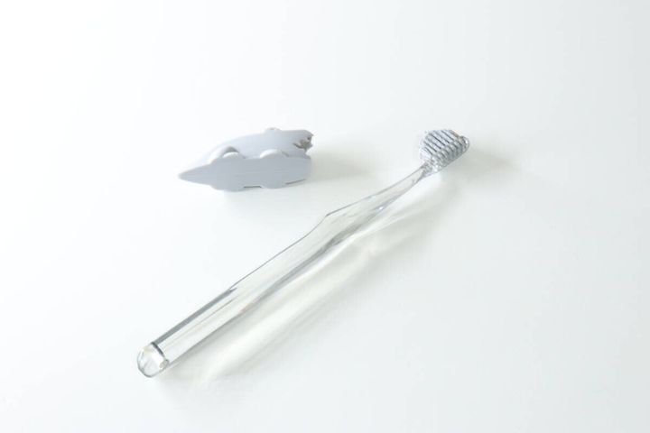 グレーのワニ型キャップと透明な歯ブラシが並ぶ