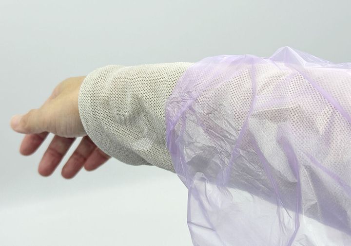 着用したレインコートの袖口から手首が出ている様子